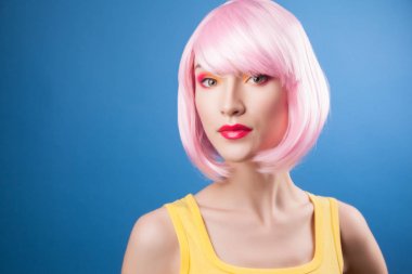 mavi arka plan karşı pembe peruk giyen güzel kadın