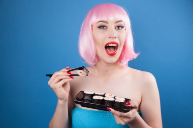 Kırmızı dudaklar ve suşi yakın çekim yemek pembe saçlı güzel kız