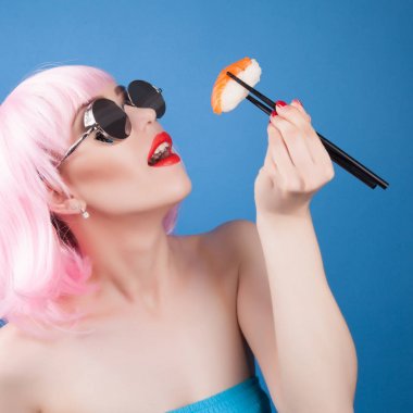 Kırmızı dudaklar ve suşi yakın çekim yemek pembe saçlı güzel kız