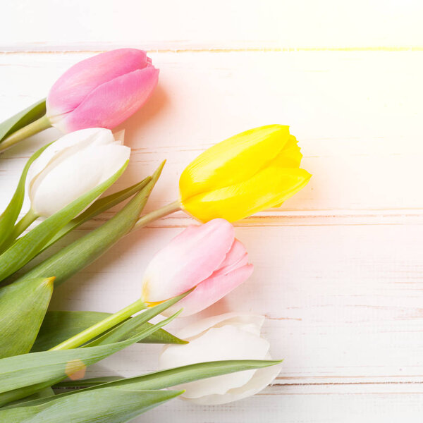 bouquet of purple, yellow and white tulips on a wooden background