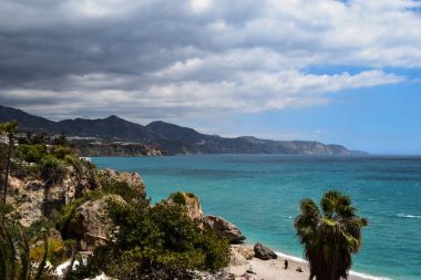 Deniz manzara plaj ve palmiye ağacı kayalarda ile görünümünü