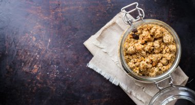 Paslı siyah masada bir kavanoza ev yapımı müsli granola