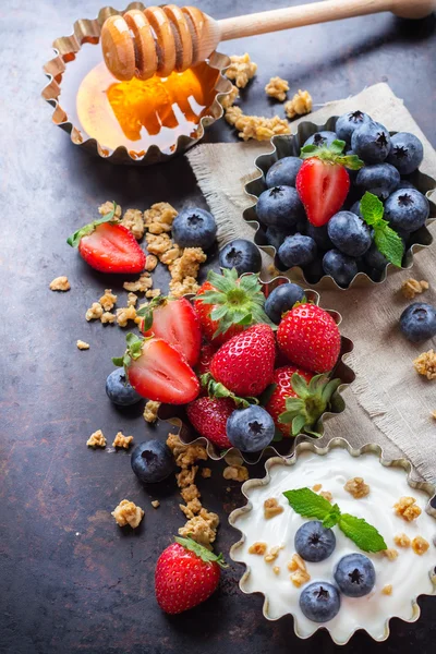 Саморобна мюслі гранола та йогурт з ягодами на іржавому столі — стокове фото