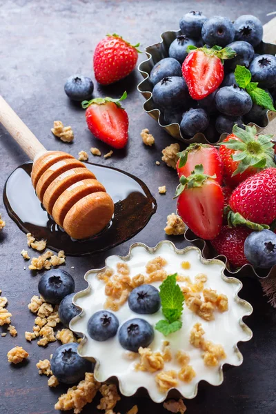 Саморобна мюслі гранола та йогурт з ягодами на іржавому столі — стокове фото