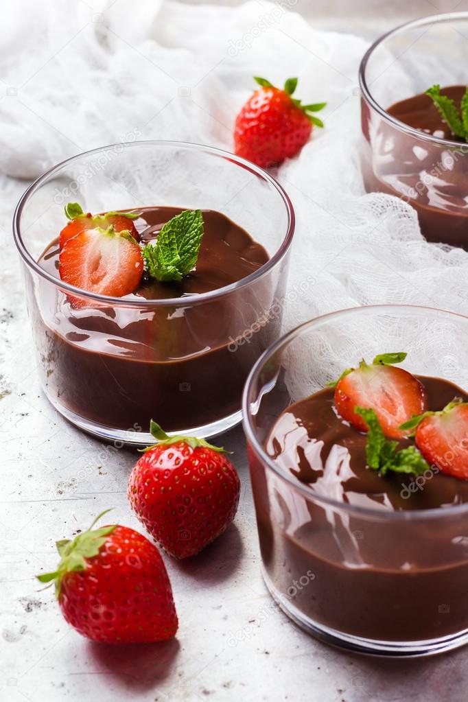 Schokoladenmousse mit Erdbeeren im Glas auf rustikalem Tisch ...