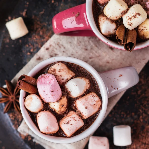 Cokelat panas dengan marshmallow dan rempah-rempah di atas meja yang gelap — Stok Foto