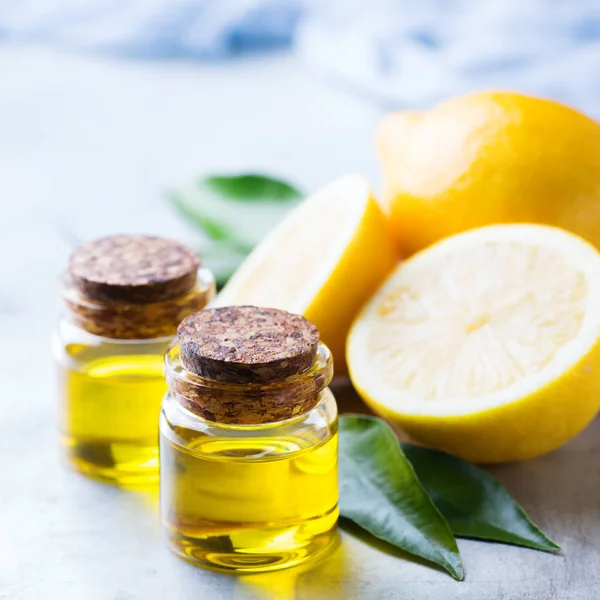 Органическое эфирное лимонное масло с зелеными листьями и фруктами — стоковое фото