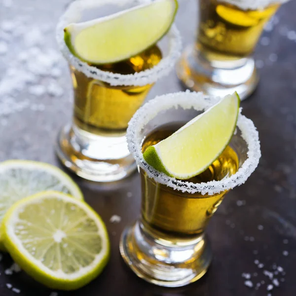 Colpo di tequila messicana dorata con lime verde e sale — Foto Stock