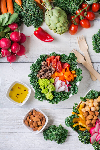 Healthy vegan buddha bowl with kale leaves and raw vegetables