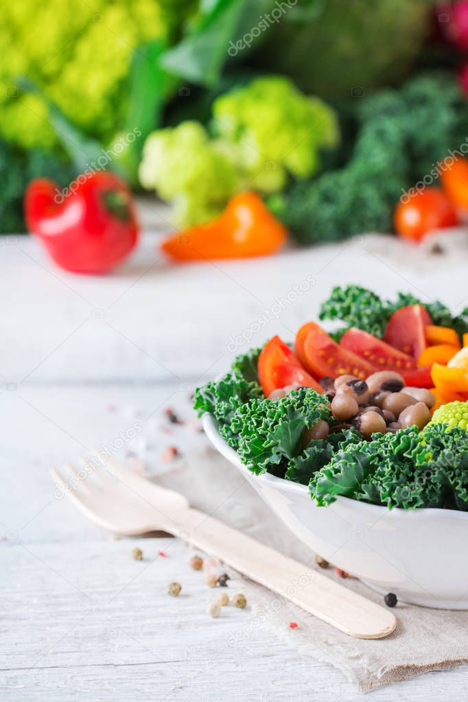 Healthy vegan buddha bowl with kale leaves and raw vegetables