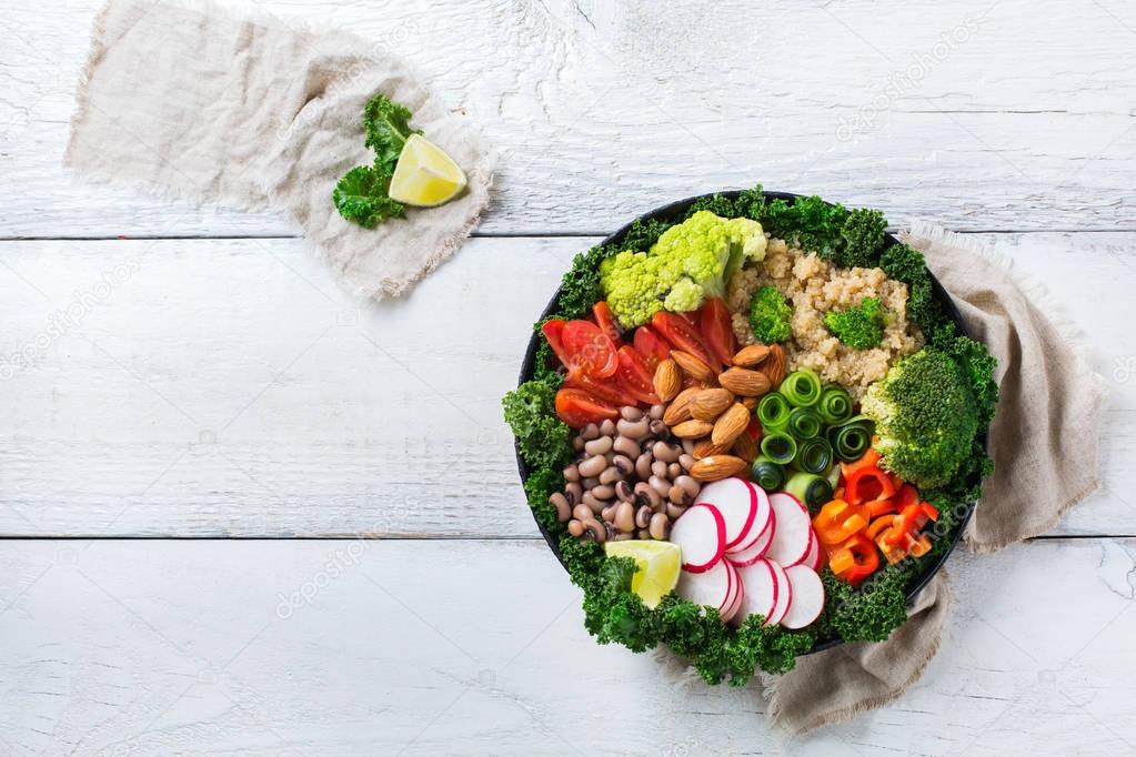 Healthy vegan buddha bowl with kale leaves and raw vegetables