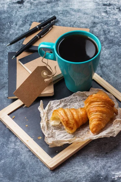 Papeterie d'affaires croissants tasse de café noir sur tableau noir grunge — Photo