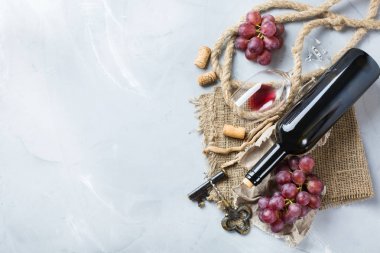 Şişe, tirbuşon, bardak kırmızı şarap, üzüm bir tablo