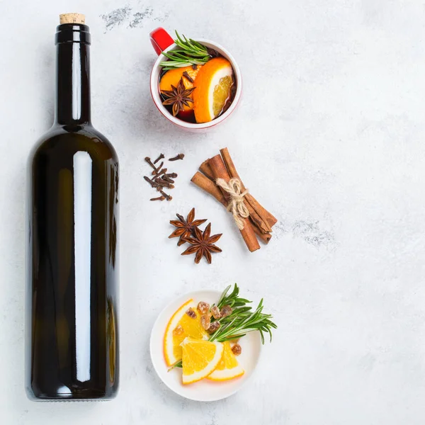 Still life, food and drink, seasonal and holidays concept. Christmas new year hot warm beverage, mulled wine ingredients, bottle, spices, orange, rosemary. Top view flat lay copy space background