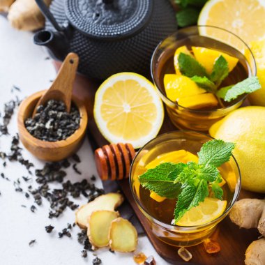 Japon Çin çay çaydanlık limon zencefil bal nane beyaz bir tablo. Sonbahar soğuk grip kış için gün içki içecek infüzyon cam sıcak