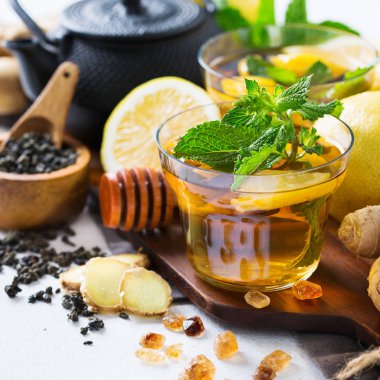 Japon Çin çay çaydanlık limon zencefil bal nane beyaz bir tablo. Sonbahar soğuk grip kış için gün içki içecek infüzyon cam sıcak
