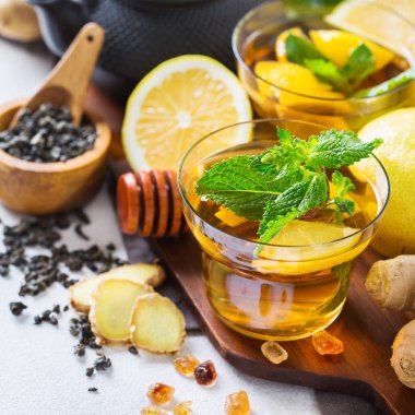 Japon Çin çay çaydanlık limon zencefil bal nane beyaz bir tablo. Sonbahar soğuk grip kış için gün içki içecek infüzyon cam sıcak