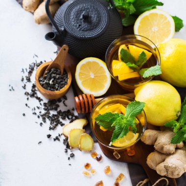 Japon Çin çay çaydanlık limon zencefil bal nane beyaz bir tablo. Sıcak içki içecek infüzyon cam soğuk grip kış sonbahar gün, en iyi görünüm düz lay