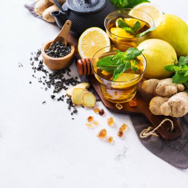 Japon Çin çay çaydanlık limon zencefil bal nane beyaz bir tablo. Sıcak içki içecek infüzyon cam soğuk grip kış sonbahar gün, kopya alan arka plan