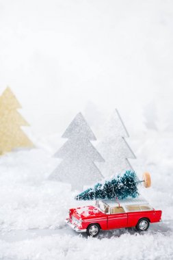 Noel ağacı bir kar ormandaki taşıyan oyuncak araba