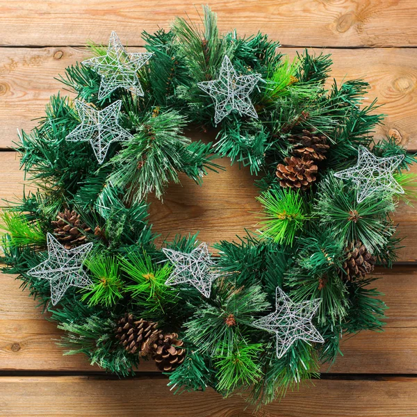 Holidays new year concept. Advent christmas door wreath with festive decoration on a cozy wooden background. Flat lay top view