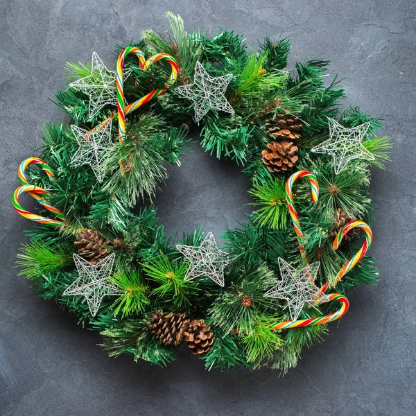 Holidays new year concept. Advent christmas door wreath with festive decoration on a cozy black background. Flat lay top view