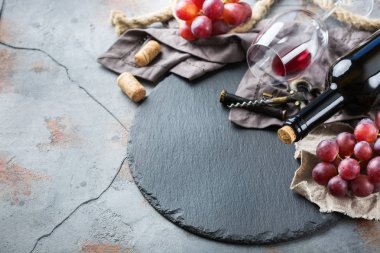 Şişe, tirbuşon, bardak kırmızı şarap, üzüm bir tablo