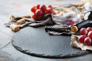 Şişe, tirbuşon, bardak kırmızı şarap, üzüm bir tablo