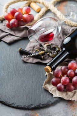 Şişe, tirbuşon, bardak kırmızı şarap, üzüm bir tablo