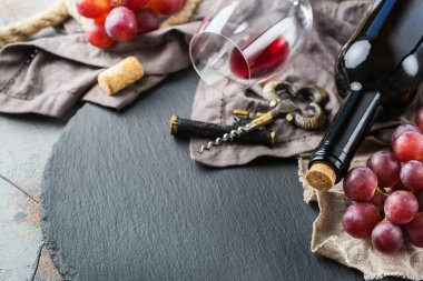 Şişe, tirbuşon, bardak kırmızı şarap, üzüm bir tablo