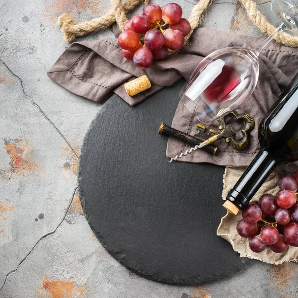 Şişe, tirbuşon, bardak kırmızı şarap, üzüm bir tablo