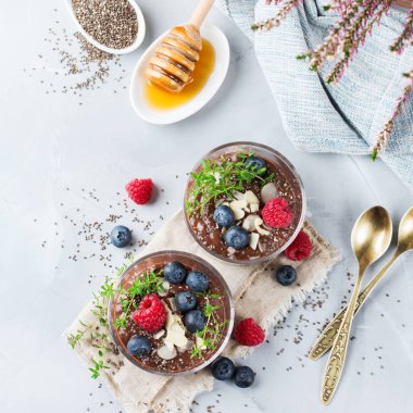 Sağlıklı vegan çikolata chia pudingi çilek ve yeşil kekik ile