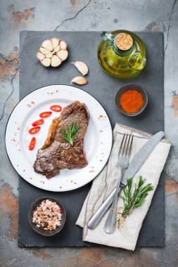 Yiyecek ve içecek konsepti. Sığır eti biftek ile baharat hazır karanlık tablo arka plan akşam yemeği için ızgara. Düz yatıyordu Üstten Görünüm