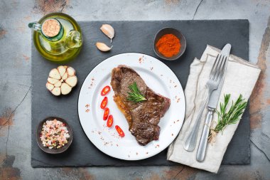 Yiyecek ve içecek konsepti. Sığır eti biftek ile baharat hazır karanlık tablo arka plan akşam yemeği için ızgara. Düz yatıyordu Üstten Görünüm