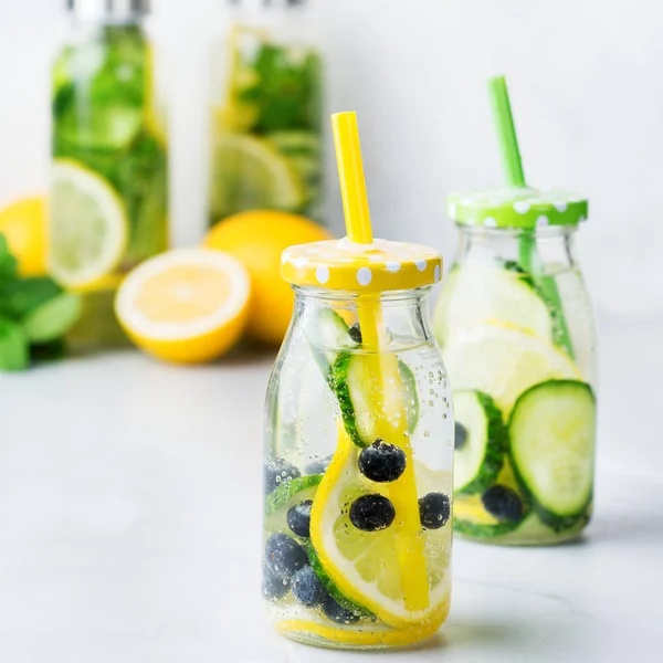 Health care, fitness, healthy nutrition diet concept. Fresh cool lemon cucumber berry infused water, cocktail, detox drink, lemonade in a glass bottle for spring summer days