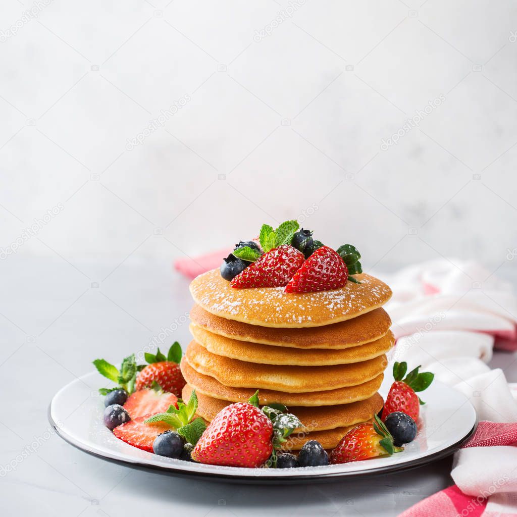 Food and drink, still life, healthy nutrition concept. Stack of homemade pancakes for breakfast with berries and sugar. Light copy space kitchen background
