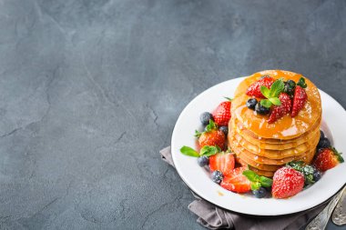 Yiyecek ve içecek, Natürmort, sağlıklı beslenme kavramı. Çilek ve bal ile kahvaltıda ev yapımı krep yığını. Karanlık kopya uzay mutfak arka plan