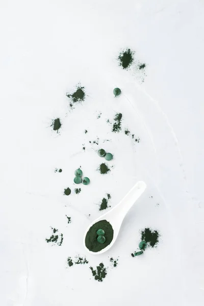 Superfood concept ground green spirulina algae powder, pills tablets