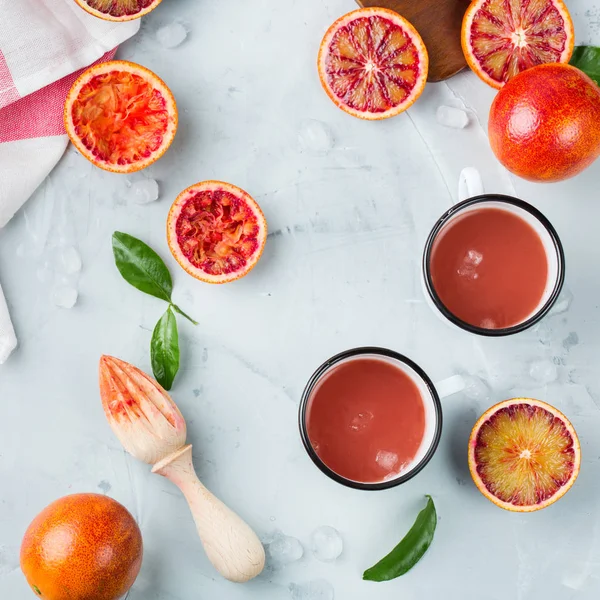 Food and drink, health care, diet and nutrition concept. Fresh red blood orange juice from ripe organic citrus fruits for breakfast on a kitchen table. Spring summer beverage, top view