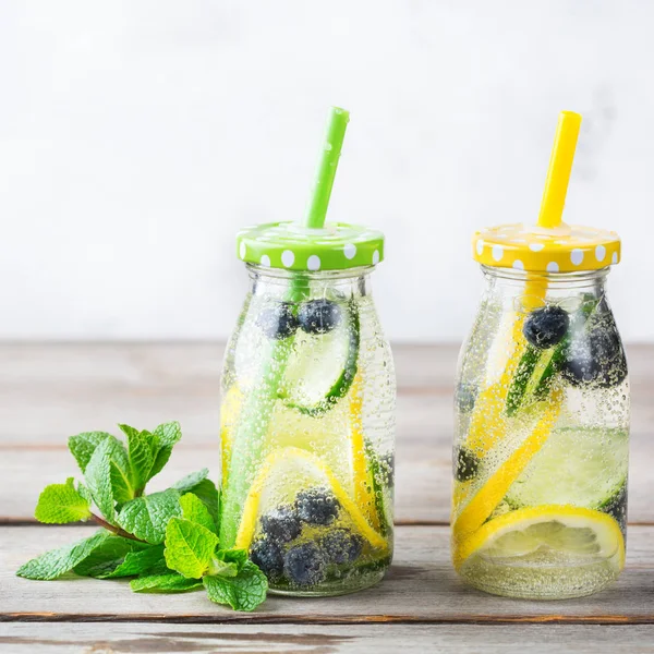 Health care, fitness, healthy nutrition diet concept. Fresh cool lemon cucumber berry infused water, cocktail, detox drink, lemonade in a glass bottle for spring summer days