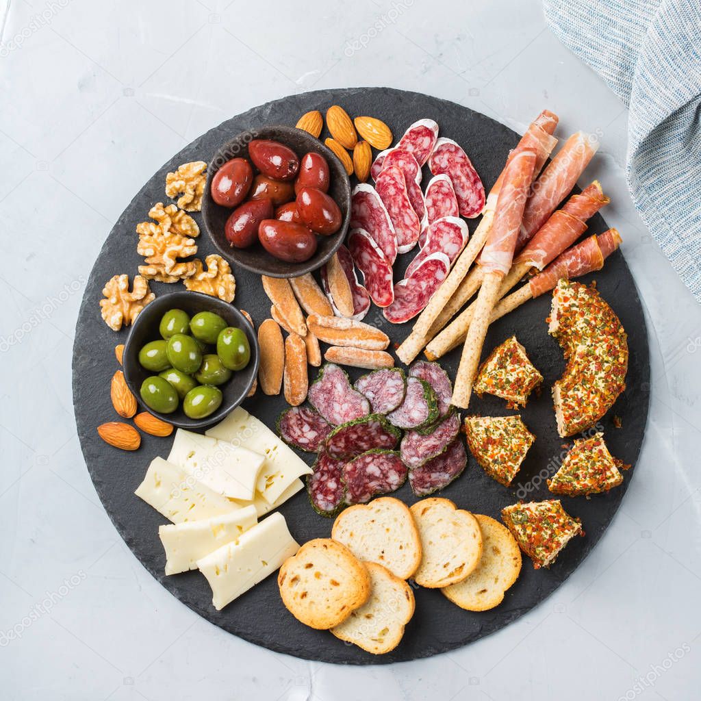 Still life, food and drink, holidays concept. Assortment of spanish tapas or italian antipasti with meat, ham, olives, cheese, nuts and bread on a table. Top view flat lay background