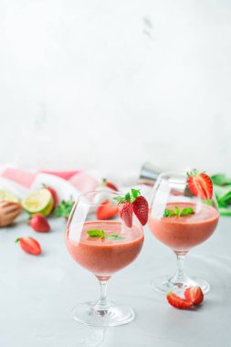 Gıda ve içecek, tatil partisi konsepti. Soğuk taze alkol içecek kokteyli votka, kireç, kırmızı çilek, Yeşil fesleğen ve ferahlık yaz günlerinde buz. Alan arka plan kopyalama