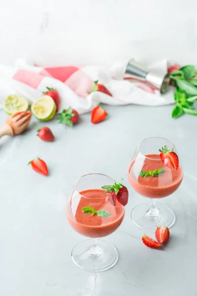 Food and drink, holidays party concept. Cold fresh alcohol beverage cocktail with vodka, lime, red strawberry, green basil and ice for refreshment in summer days