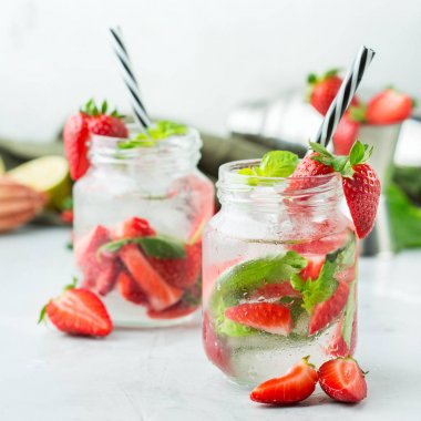 Gıda ve içecek, tatil partisi konsepti. Soğuk taze alkol içecek mojito beyaz rom, soda, kırmızı çilek ve yaz günlerinde serinlemek için fesleğen ile kokteyl