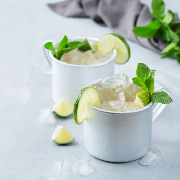 Food and drink, holidays party concept. Cold fresh classic alcohol beverage moscow mule cocktail in a silver mug with vodka, ginger beer. lime and mint for refreshment in summer days