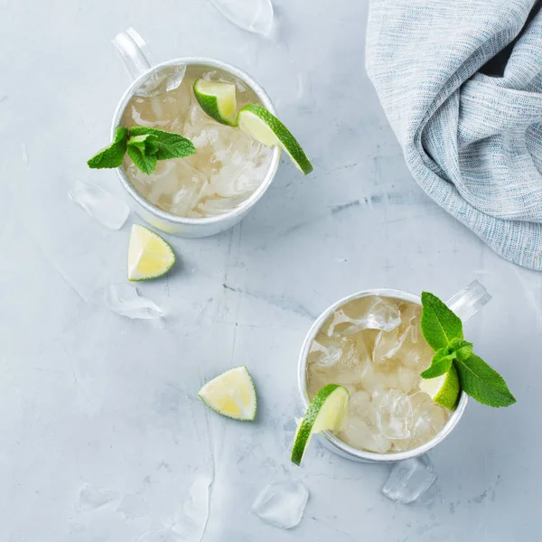 Food and drink, holidays party concept. Cold fresh classic beverage moscow mule cocktail in a silver mug with vodka, ginger beer. lime and mint for refreshment in summer days. Top view flat lay