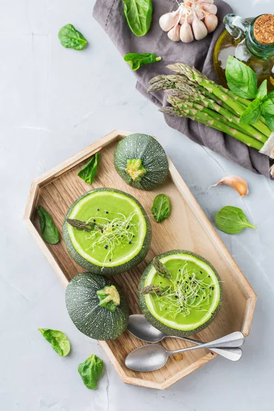 Food and drink, healthy eating and dieting concept. Seasonal fresh organic creamy asparagus spinach soup served in a round zucchini on the kitchen table. Top view flat lay background — Stock Image Food Drink Healthy Eating Dieting Concept Seasonal Fresh Organic Creamy Royalty Free Stock Images