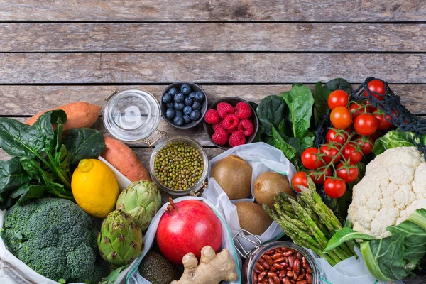 Meyve ve sebzeli tekstil ağı torbası. Sıfır atık, çevre dostu, plastiksiz geri dönüşümlü, yeniden kullanılabilir, sürdürülebilir market alışverişi konsepti. Boşluğu kopyala, düz arkaplan 