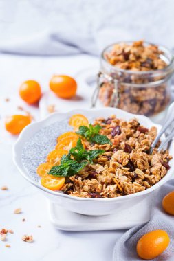 Organik vejetaryen sağlıklı beslenme ve diyet gıda konsepti. Kahvaltı için taze ev yapımı granola, portakallı kumkat ve yeşil naneli vejetaryen chia pudingi.