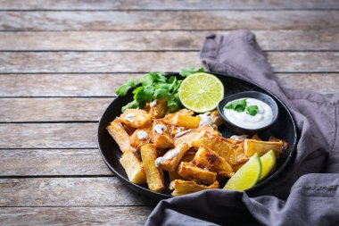 Brezilya mutfağı, latin yemeği. Kızarmış yucca, yuca, cassava, kişniş soslu manyok çubukları. Boşluk arkaplanı kopyala  